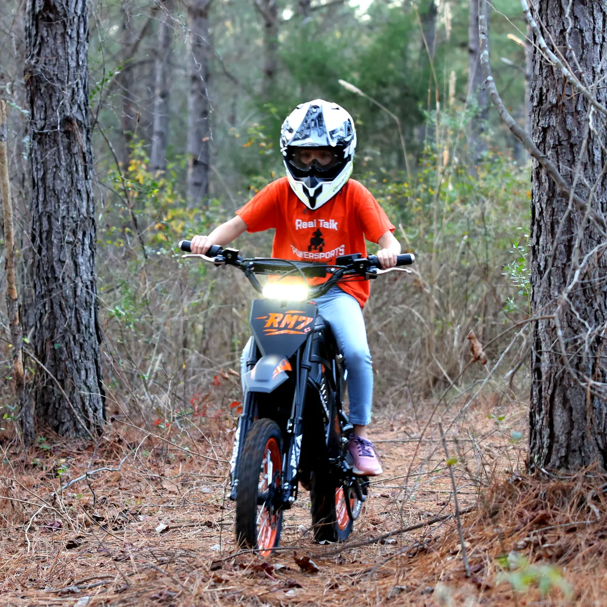 Woman rider on Windone RM7 electric dirt bike on forest trail